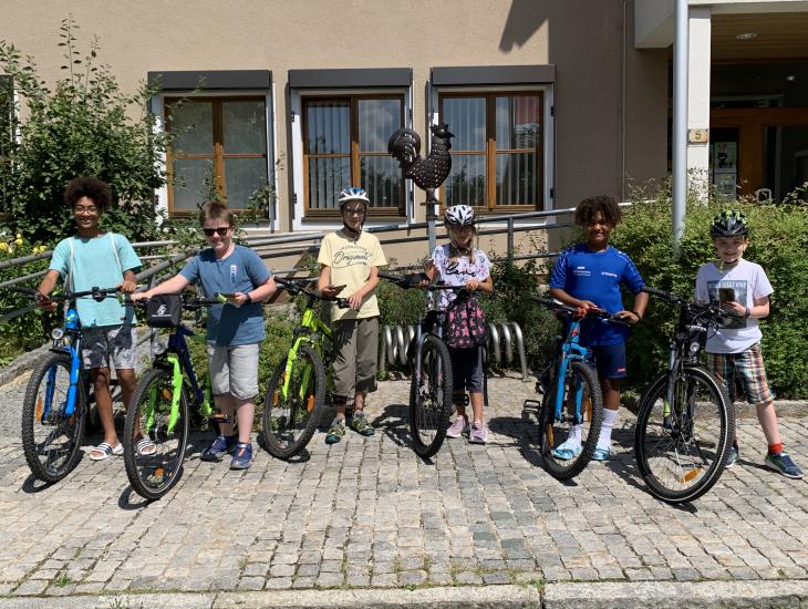 Fahrrad und Handy parat – die Actionbound-Tester starten das Hahnbacher Abenteuer bei der Jubiläumsfahne vor dem Rathaus.